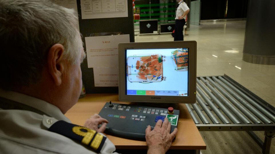 On guard: customs officer Declan Smyth scans luggage at Dublin Airport. Photograph: Brenda Fitzsimons