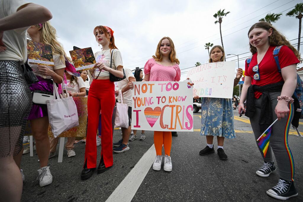 A woman holds a sign reading 'Not too young to know I like girls' at the 2023 LA Pride Parade. Photograph: Robyn Beck/Getty Images
