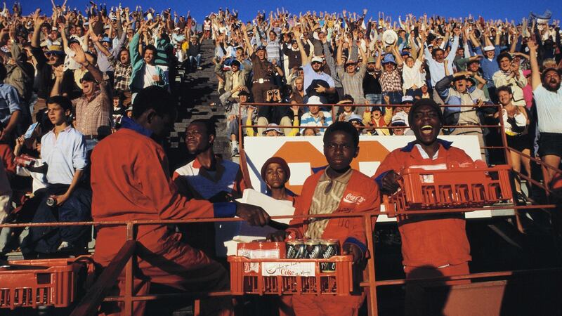 Black snack vendors look on while the predominately white crowd cheers at a rugby game in Loftus Versfeld stadium in Pretoria, South Africa. Photograph: Gideon Mendel/Corbis via Getty Images