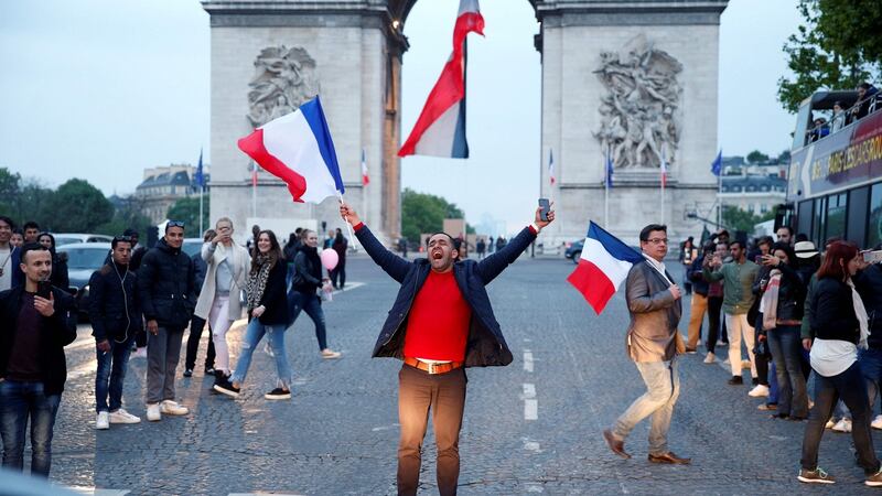A man celebrates Emmanuel Macron’s win in the presidential election on the French avenue of the Champs Élysées by the Arc de Triomphe in Paris. Photograph: Geoffroy Van Der Hasselt/AFP/Getty Images