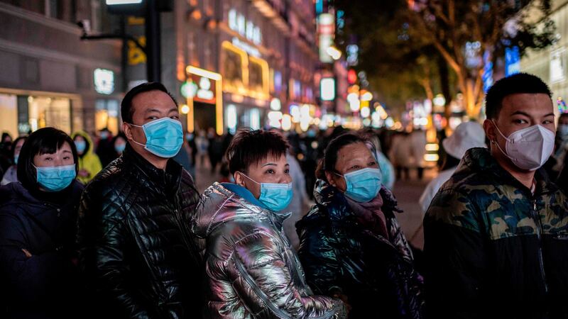 People stand around a giant 3D screen on Jianghan street in Wuhan on Sunday, the eve of the first anniversary of China confirming its first death from the Covid-19 coronavirus. Photograph: Nicolas Asfouri/AFP via Getty Images