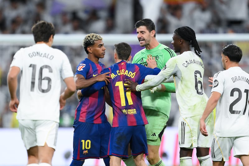 Lamine Yamal of FC Barcelona is held back by Marc Casado as Real Madrid players Thibaut Courtois and Eduardo Camavinga clash with him after the match at Estadio Santiago Bernabeu on Sunday in Madrid. Photograph: David Ramos/Getty Images