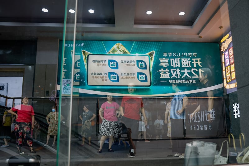 Elderly people take a break after dancing outside a Huawei store in Beijing, China. Photograph: Mark R Cristino/EPA