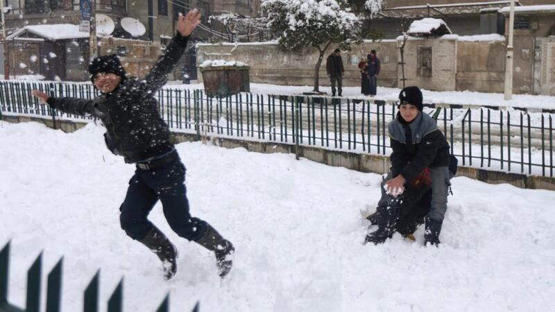 Children play in the snow in Douma, near Damascus on Sunday. Met Éireann has issued status yellow warnings for snow and ice between Monday and Wednesday. Photograph: REUTERS/Bassam Khabieh