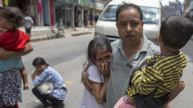 Local residents evacuate onto a street minutes after an earthquake in central Kathmandu. At three people were killed and more than 300 injured in Nepal. Photograph: Athit Perawongmetha/Reuters
