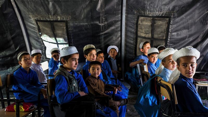Religious students attend class in a tent outside the madrasa in Charikar, Afghanistan. Photograph: Jim Huylebroek/New York Times