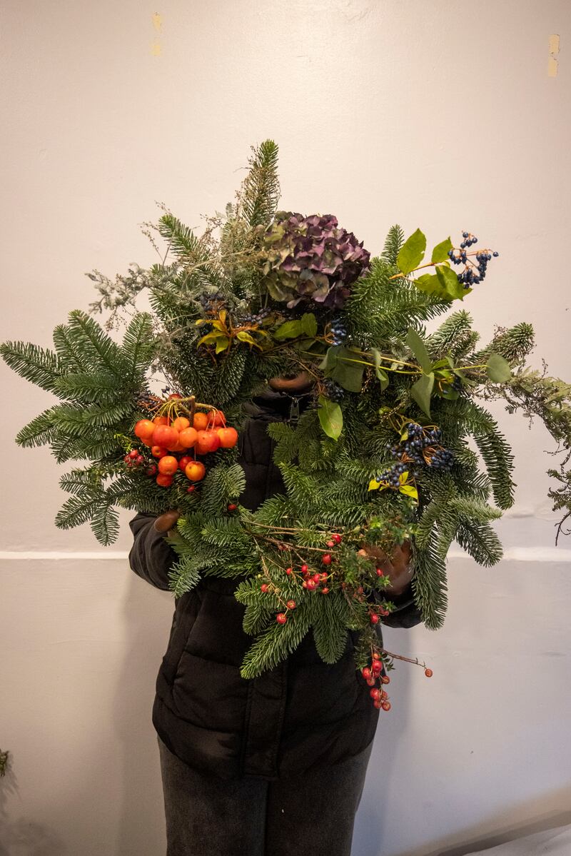A participant holds up a completed wreath at the Spirasi workshop. Photograph: Tom Honan