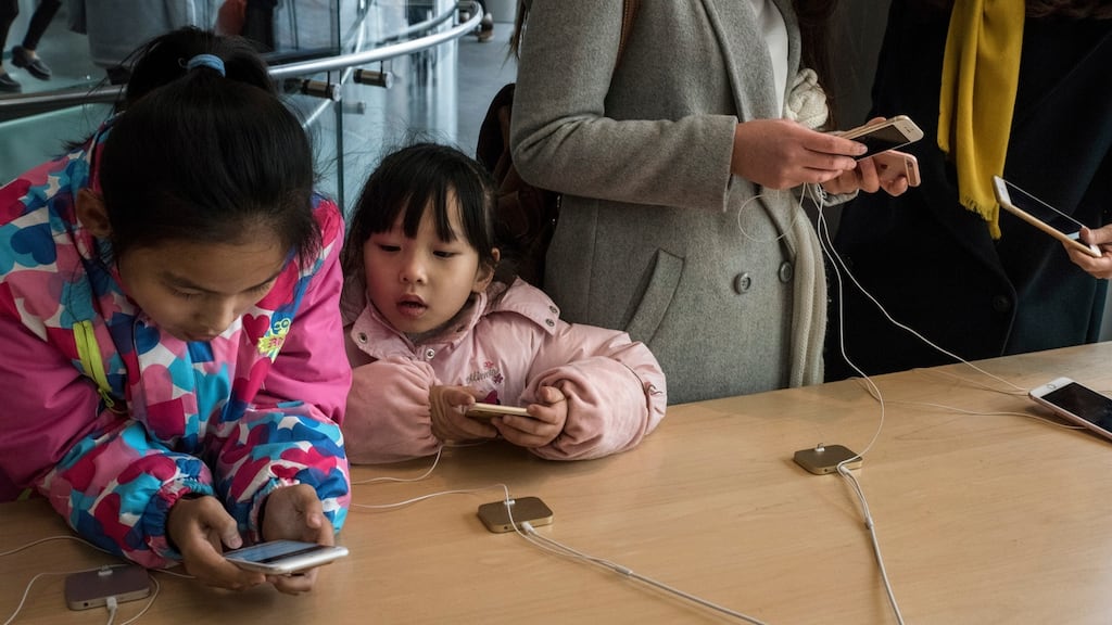 Visitors at an Apple store handle new iPhones in Beijing