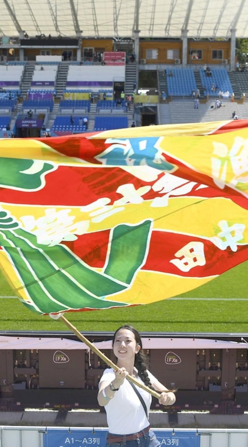 A woman waves a fishermen’s flag ahead of the Fiji and Uruguay match in Kamaishi last month. Photograph: Kyodo News via Getty Images