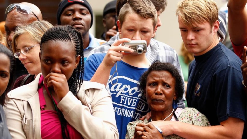People comfort each other outside the residence of former South African President Nelson Mandela in Johannesburg. Photograph: Reuters/Siphiwe Sibeko