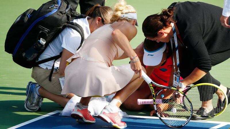 Caroline Wozniacki of Denmark (second left) checks on Shuai Peng of China after she slumped to the ground during their semi finals at the US Open. Photograph: Andrew Gombart/ EPA