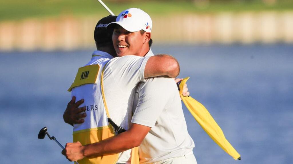 Si Woo Kim of South Korea embraces his caddie Mark Cavens after winning the Players Championship at TPC Sawgrass. Photo: Tannen Maury/EPA