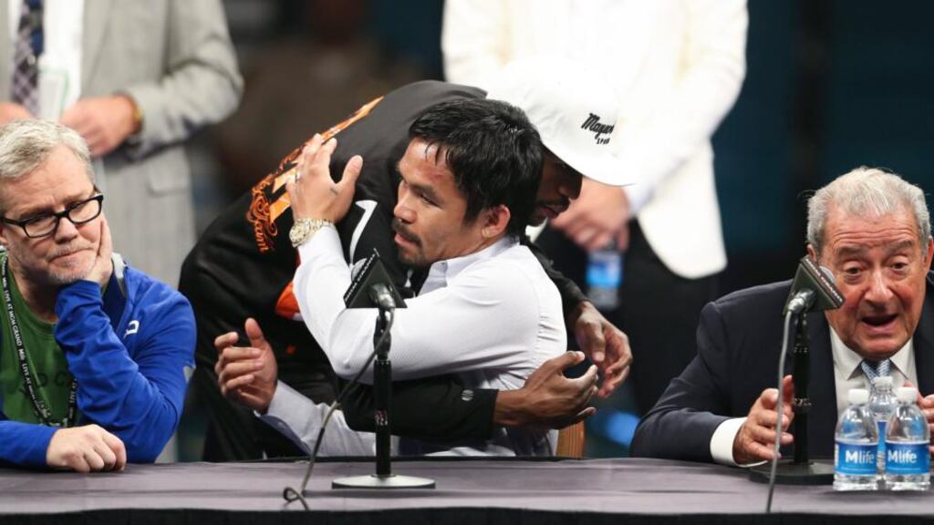 Manny Pacquiao is hugged by Floyd Mayweather at the post-fight press conference. Also pictured are Pacquiao’s trainer Freddie Roach and boxing promoter Bob Arum. Photo: EPA