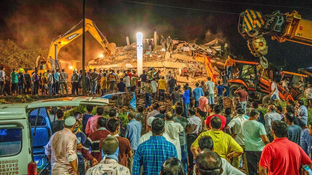 Rescue workers search for people in the rubble of a five-storey building after it collapsed in Mahad, India. Photograph: Pritam Sakpal/AFP via Getty Images