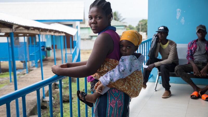 A woman and baby wait next to a tuberculosis ward at the TB Annex Hospital in Monrovia. Photograph: Sally Hayden