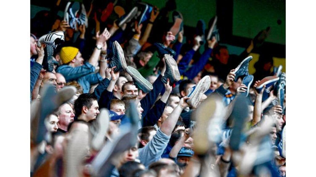 Leeds United supporters wave their shoes in the air as they sing during their FA Cup fifth round match against Manchester City at The Etihad Stadium. Photograph: Reuters/Phil Noble