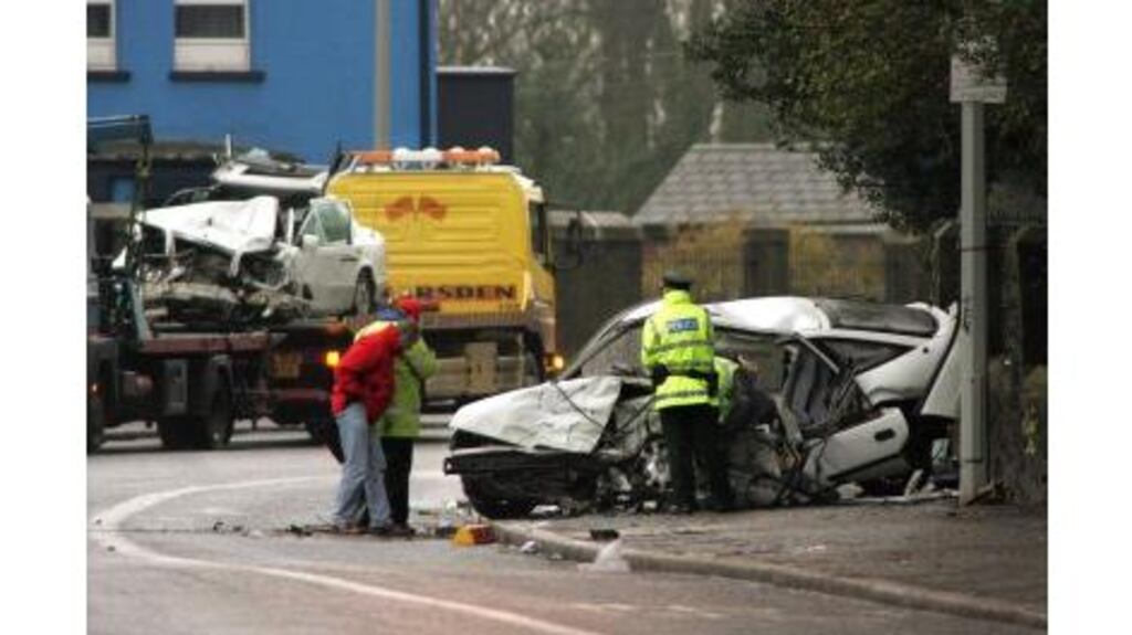 PSNI officers sealing off the Falls Road in Belfast yesterday morning after a fatal car crash. Two people died and eight were injured.