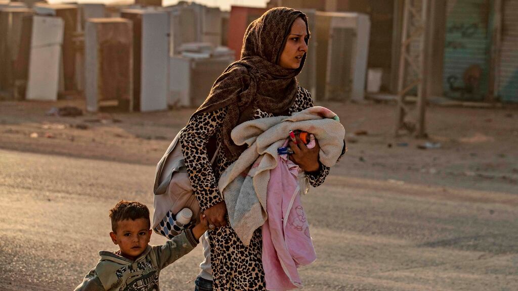 A woman flees with her children amid Turkish bombardment on Syria’s northeastern town of Ras al-Ayn in the Hasakeh province along the Turkish border. Photograph: Delil Souleiman