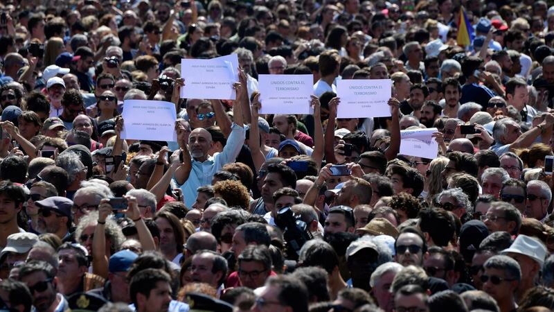 People brandish messages before a minute’s silence for the victims of the Barcelona attack at Plaça de Catalunya on Friday. Photograph: Javier Soriano/AFP/Getty Images