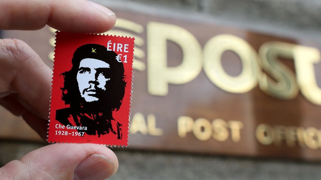 The stamp featuring an image by Irish artist Jim Fitzpatrick, of Argentine revolutionary leader Ernesto “Che” Guevara is held up outside the General Post Office (GPO) in Dublin. Photograph: Paul Faith/AFP/Getty Images