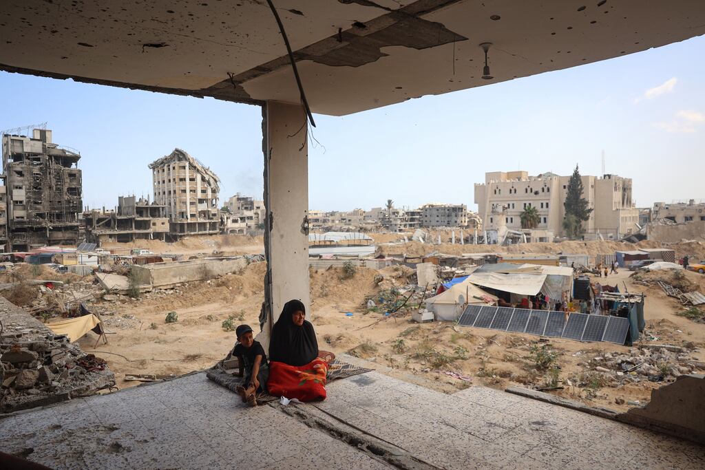 A Palestinian family sits in the remains of their damaged home, as some residents return to the city of Khan Yunis in southern Gaza on Sunday. Photograph: Eyad Baba/AFP via Getty
