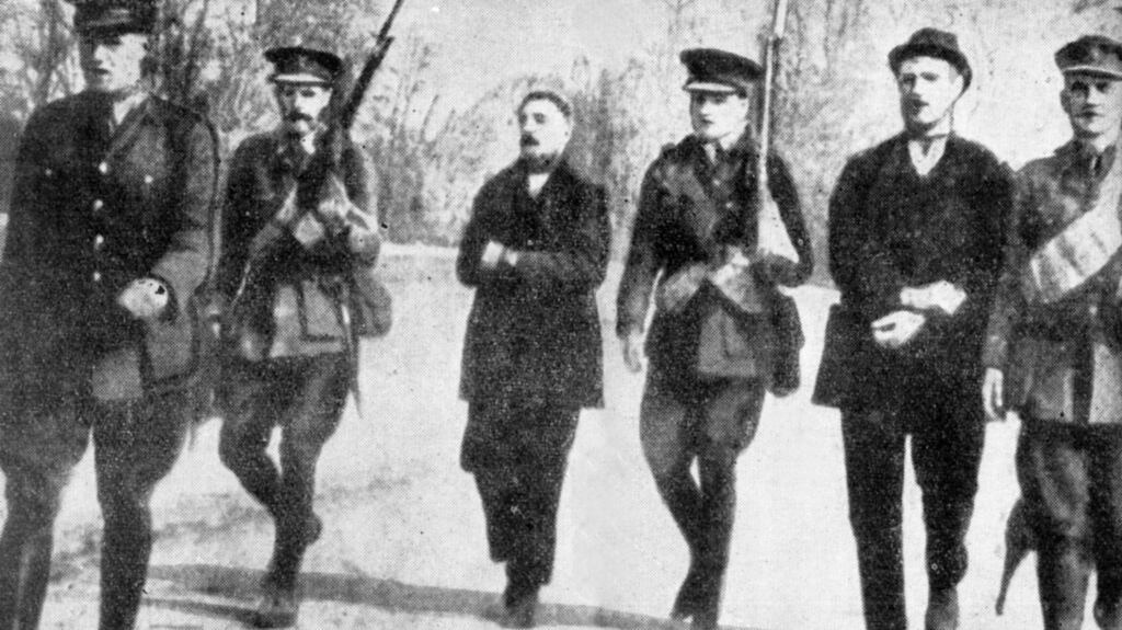 May 1916: Thomas (left) and William Kent being marched by British soldiers across Fermoy bridge.