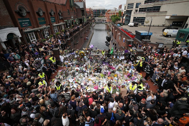 Members of the public view tributes at the Black Sabbath Bench as Ozzy Osbourne's funeral cortege travels through his home city of Birmingham. Photograph: Christopher Furlong/Getty Images