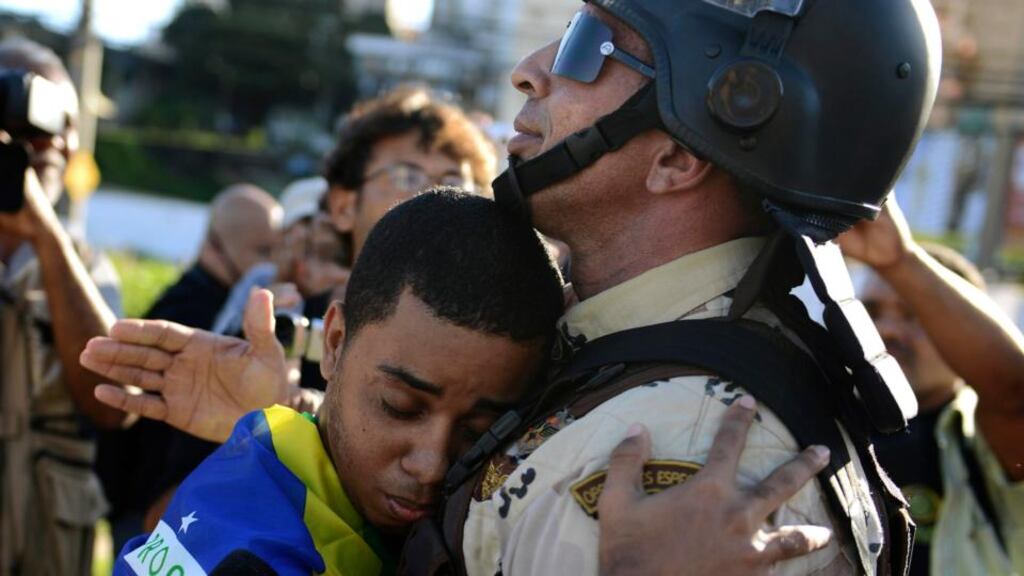 A demonstrator embraces a police commander in a gesture of peace during a protest in Salvador. Photograph: Reuters/Valter Pontes