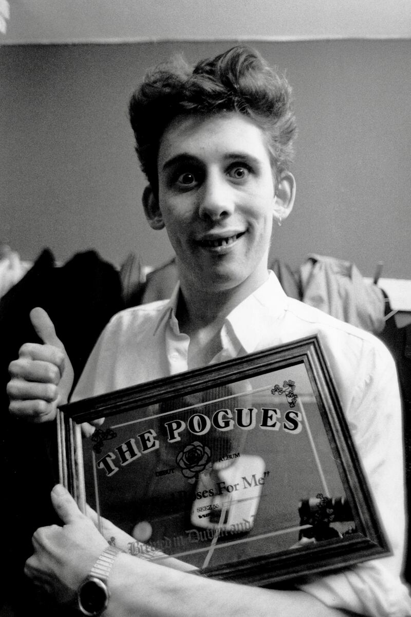 Shane MacGowan holds a mirrored plaque that references the Pogues' 1984 album Red Roses for Me. Photograph: Steve Rapport/Getty Images