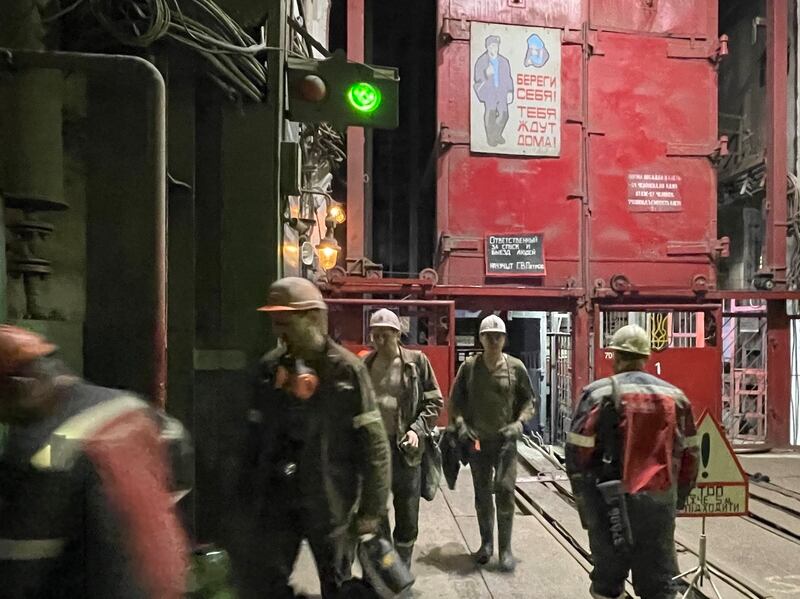 Miners emerge from the lift after a shift 800m underground at the Pokrovsk mine in eastern Ukraine. The sign above the lift reads: 'Take care of yourselves! People are waiting for you at home!' Photograph: Daniel McLaughlin