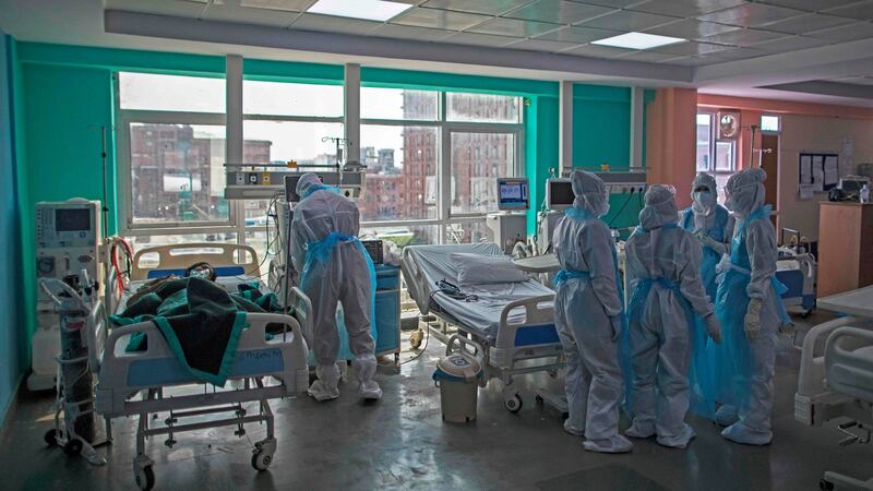 Doctors and nurses wearing Personal Protective Equipment (PPE) gather next to a coronavirus patient at the intensive care unit of the Sharda Hospital in Greater Noida. Photograph: Xavier Galiana/AFP/Getty