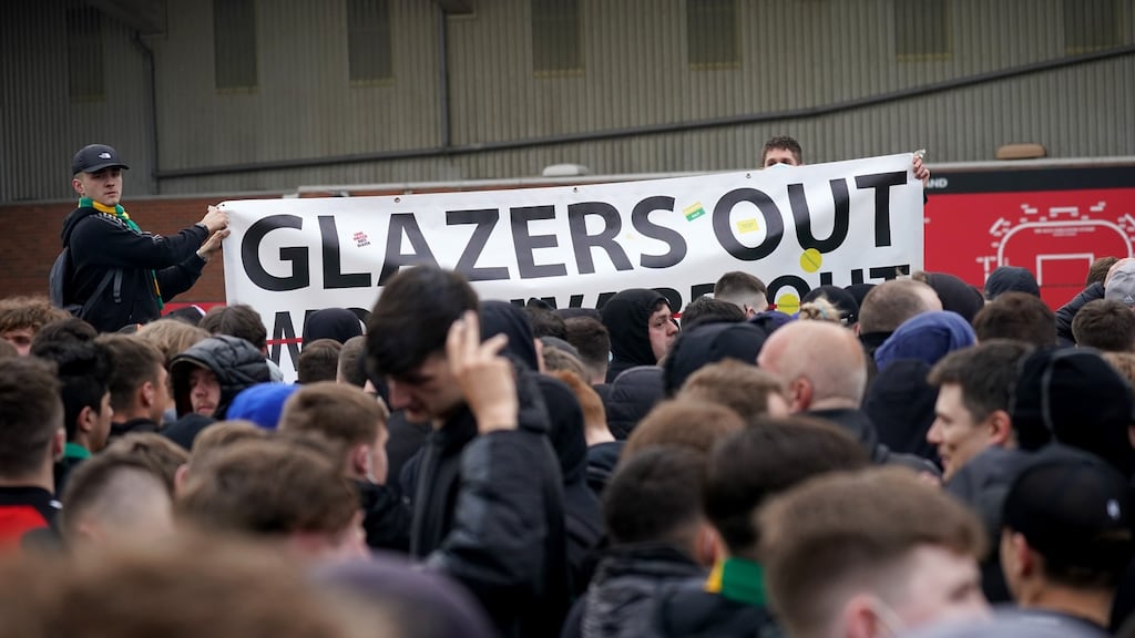Protesters holding a banner reading ‘Glazers Out’ stand outside Old Trafford. Photo: Christopher Furlong/Getty Images