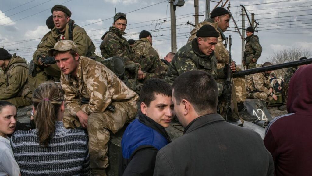 Villagers talk with Ukrainian soldiers yesterday as they gather at a railway to stop Ukrainian tanks moving towards the airport. The start of what the Ukrainian government has called a military operation stalled when six armoured personnel carriers were seized. Photograph: Mauricio Lima/The New York Times