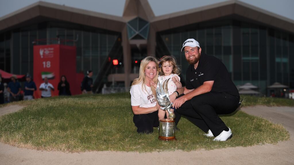 Shane Lowry celebrates with wife Wendy Honner, daughter Iris Lowry and the trophy after winning the Abu Dhabi HSBC Golf Championship. Photo: Ross Kinnaird/Getty Images