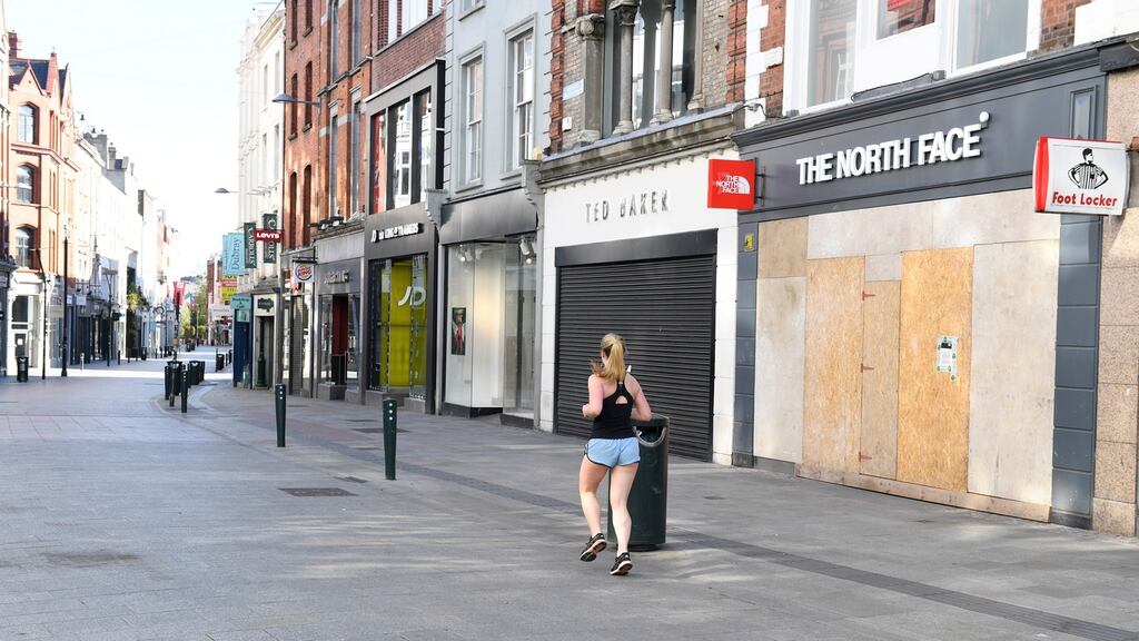 A woman jogs down a deserted Grafton Street in Dublin. Initial hopes of a 12-week closure and a quick reopening for businesses have long disappeared. Photograph: Aidan Crawley/EPA