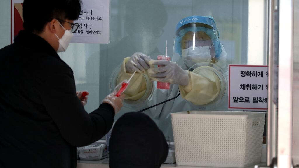 A medical professional take samples from people at a preliminary testing center on Friday  in Seoul, South Korea. Photograph: Chung Sung-Jun/Getty Images