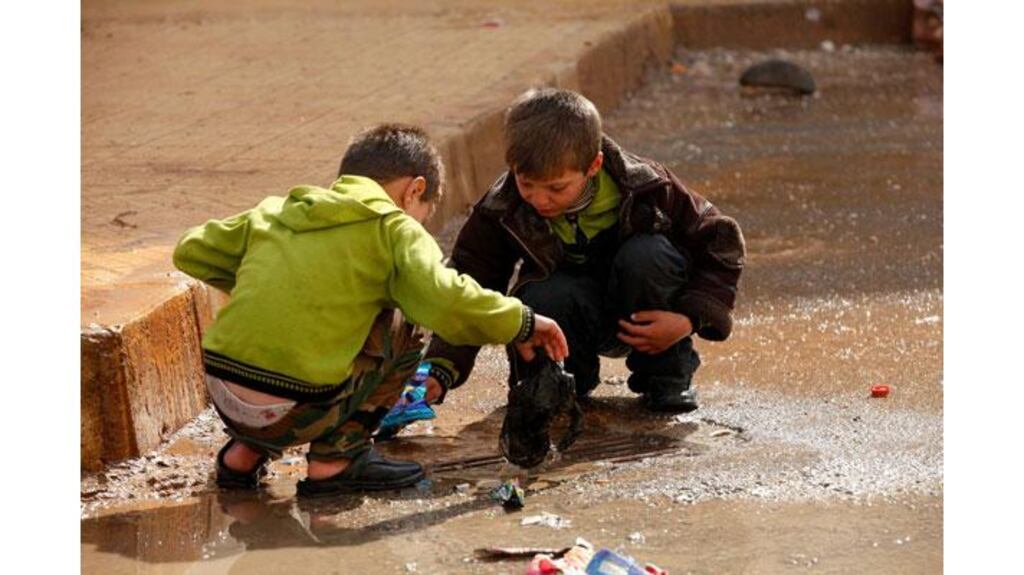 Children remove trash blocking the drains in the Al Inzarat district in Aleppo. Photograph: Reuters