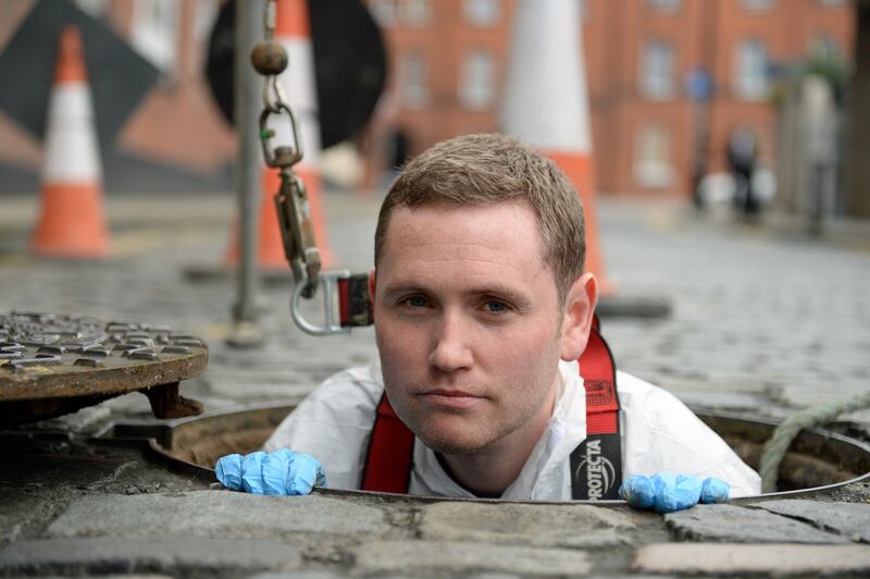 Karl Whitney, author of Hidden City: Adventures and Explorations in Dublin,  at a manhole entrance to the sewerage system and to the river Poddle on Ship Street in Dublin. Photograph: Frank Miller