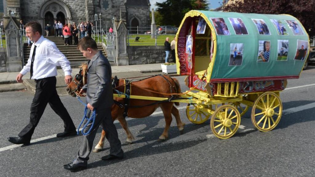 A miniature version of a traditional Travellers’ barrel caravan bearing pictures of the O’Driscoll twins, Patrick and Thomas, is led past Holy Cross Church in Charleville yesterday. Photograph: Daragh McSweeney/Provision