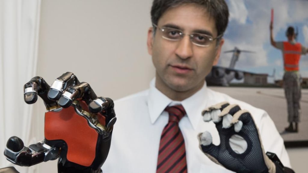 Cutting edge: Kapil Katyal, a robotics engineer, with a Darpa-sponsored robotic hand and arm; the prosthesis mimics the movement of the sensor glove he is wearing. Photograph: Paul J Richards/AFP/Getty