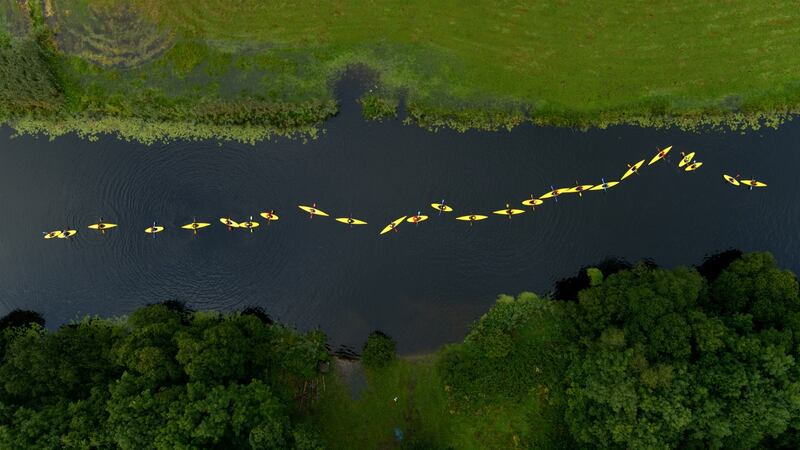 Yellow kayaks form a line as part of Suzanne Lacey’s Border artwork.