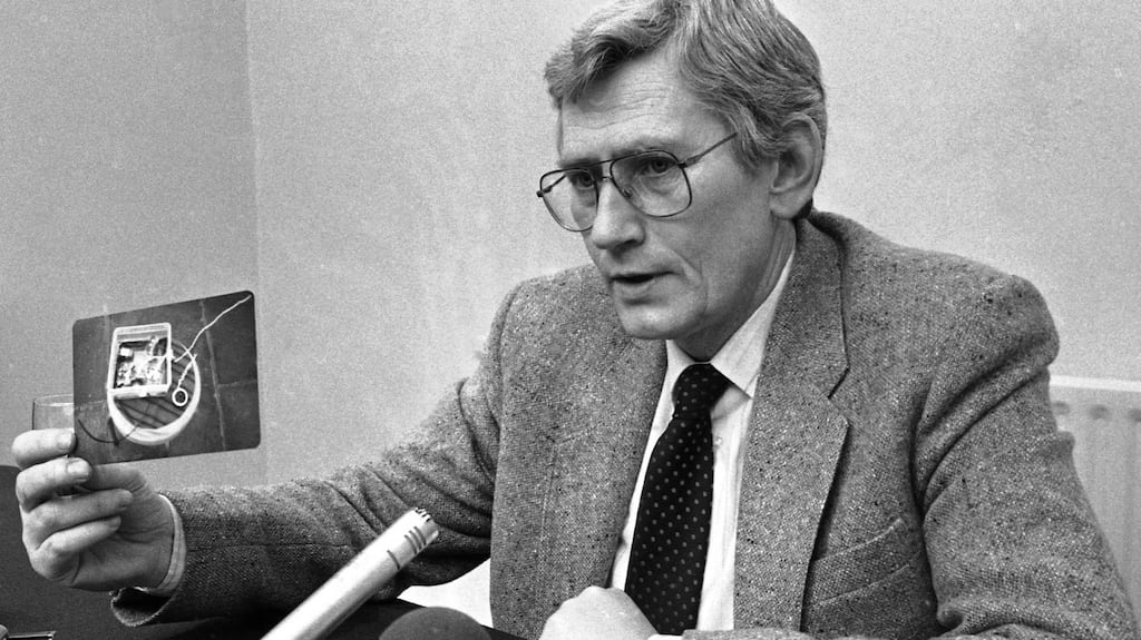 Seamus Mallon in 1984, holding up one of the pictures taken of the bugging equipment found in the house in Kilbarrack, Dublin, where he stayed occasionally. Photograph: Kevin McMahon