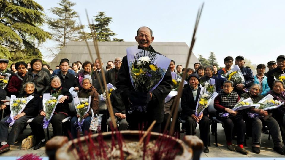 She Ziqing, a child survivor of the Nanjing massacre in the 1930s, presents flowers during a ceremony at the Nanjing Massacre Museum on Tomb Sweeping Day in Nanjing, Jiangsu province, China. Over 50 massacre survivors and family members of victims attended the ceremony. Photograph: Reuters