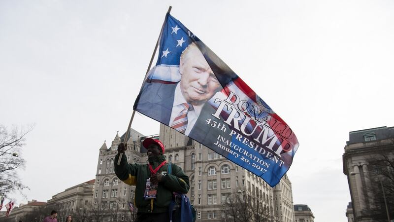 A vendor sells Donald Trump flags while standing in front of Trump International Hotel in Washington, DC, the day before Mr Trump is inaugurated as president of the United States. Photograph: David Paul Morris/Bloomberg
