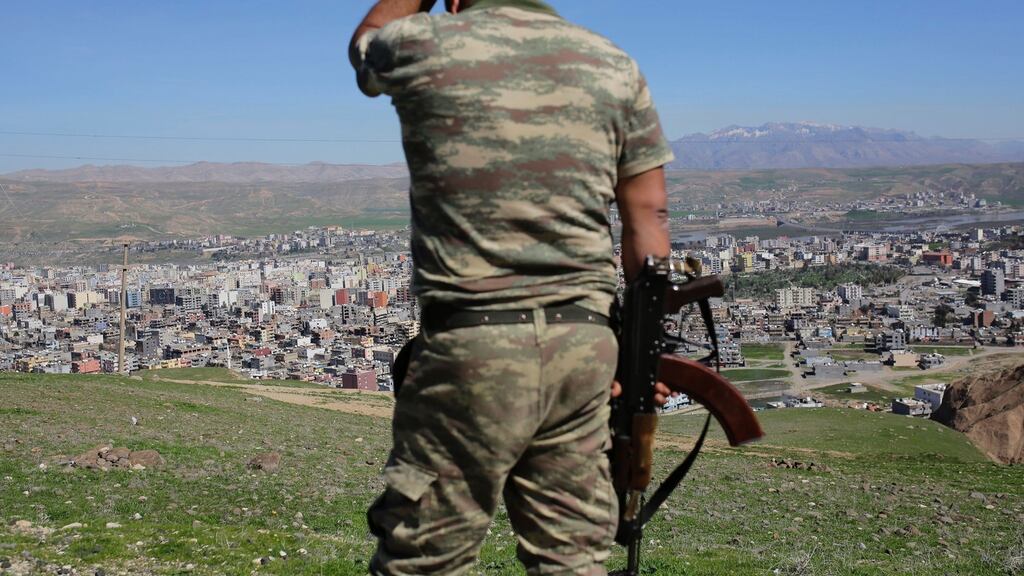 A Turkish soldier stands on the hill overlooking damaged buildings following heavy fighting between government troops and Kurdish fighters near the border with Syria and Iraq. The failed military coup on July 15th left the Turkish army humiliated when it is facing the Kurdish unrest and the fight against Islamic State. Photograph: Yasin Akgul/AFP/Getty Images
