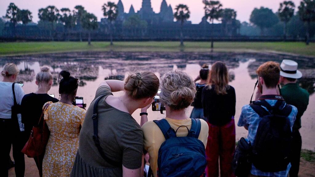 Tourists watch the sun rise over the Angkor Wat temple complex in Cambodia: Tourism creates value, enriches cultural exchange, expands minds and spreads wealth from richer parts of the world to developing regions. Photograph: Tang Chhin Sothy/AFP via Getty Images