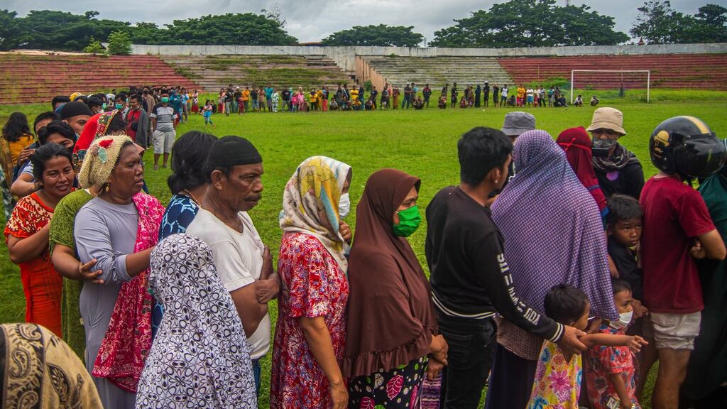 People queue for food and blankets during aid distribution in the aftermath of the 6.2 magnitude earthquake at a stadium in Mamuju, West Sulawesi, Indonesia. Photograph: EPA/Iqbal Lubis