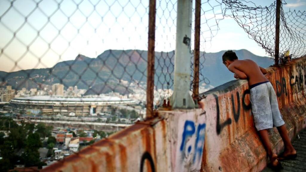 A boy looks out from the Mangueira community, or favela, which overlooks Maracana Stadium in Rio de Janeiro, Brazil. Photograph: Mario Tama/Getty Images
