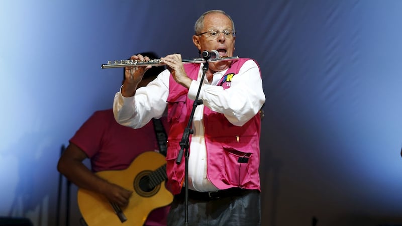 Peruvian presidential election candidate Pedro Pablo Kuczynski plays the flute in a concert during his closing campaign meeting in Lima on Wednesday. Photograph: Mariana Bazo/Reuters