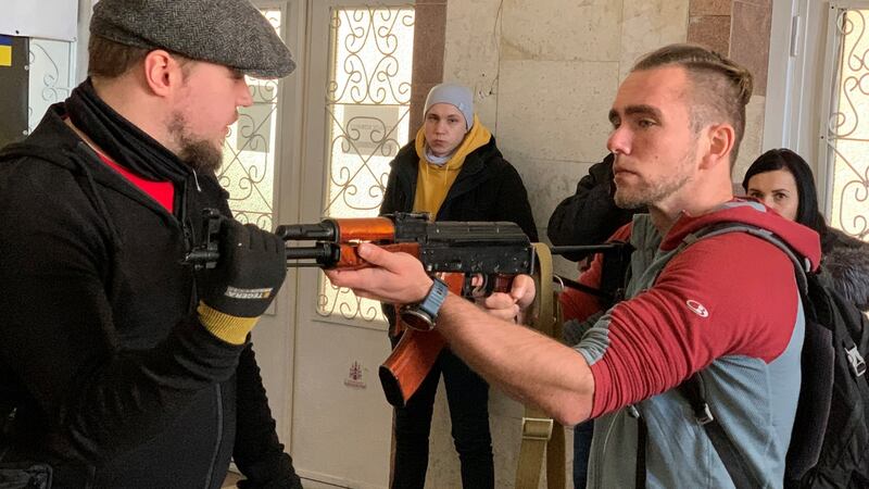 Weapons instructor Tomi Hiltunen shows Kostya Leschenko, a software engineer, the recoil effect of a Kalashnikov rifle. Photograph: Lara Marlowe